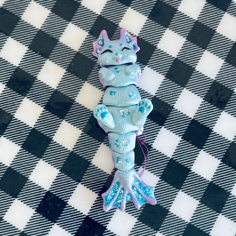 Meet TidalTwinkle the MerCat! A 3D-printed, hand-painted fidget collectible with silky teal and purple hues. Magical, calming, and perfect for ocean lovers!