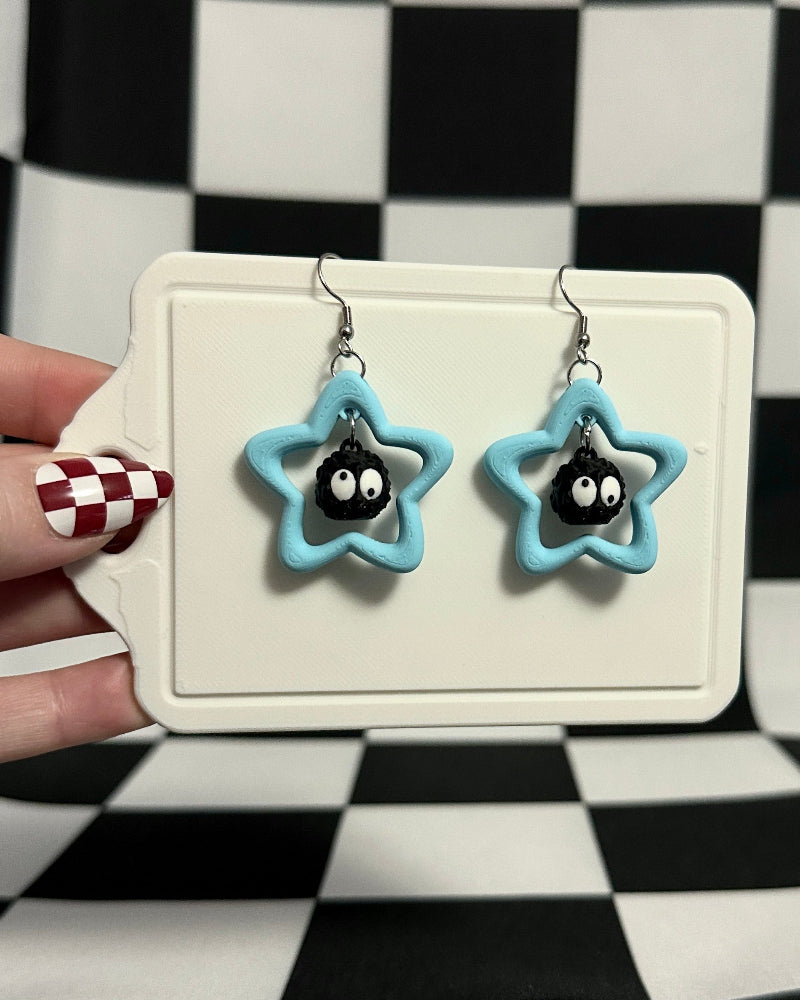 Star-shaped earrings on a display card against a checkered background