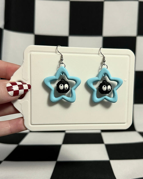 Star-shaped earrings on a display card against a checkered background