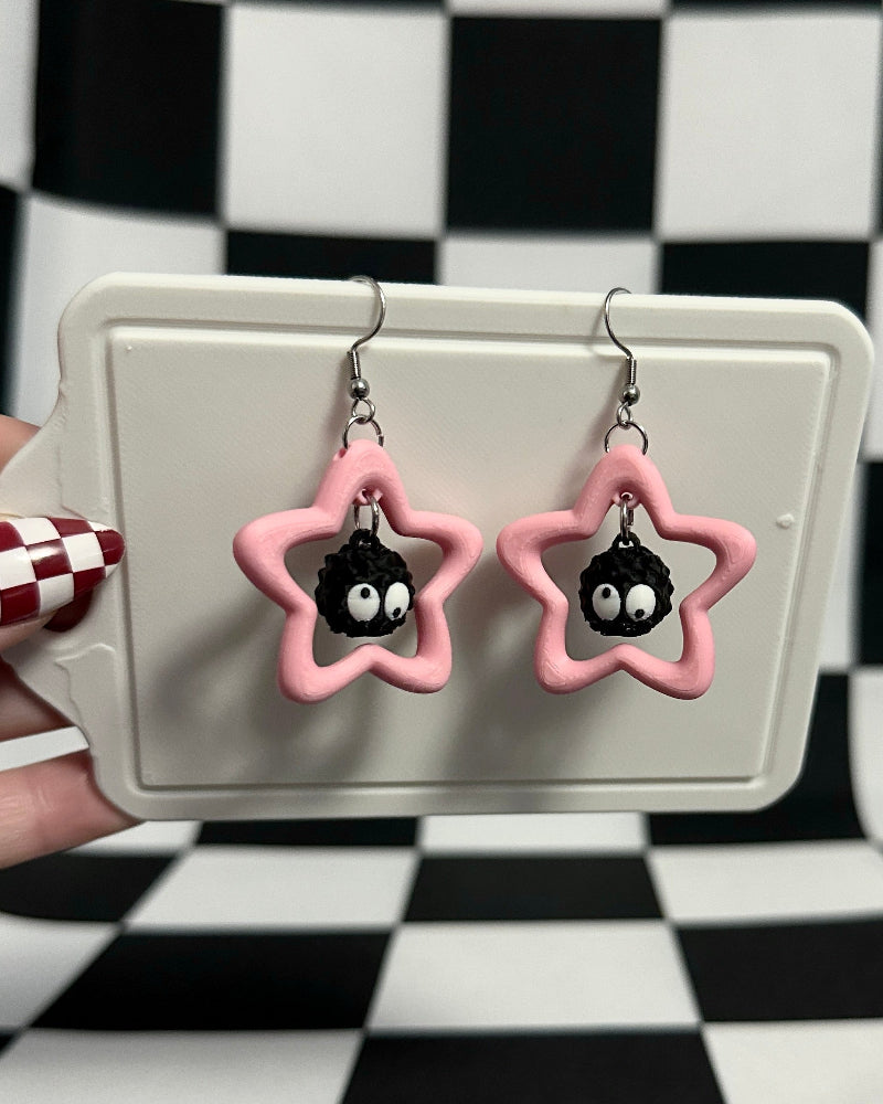Star-shaped earrings with penguin design on a checkered background