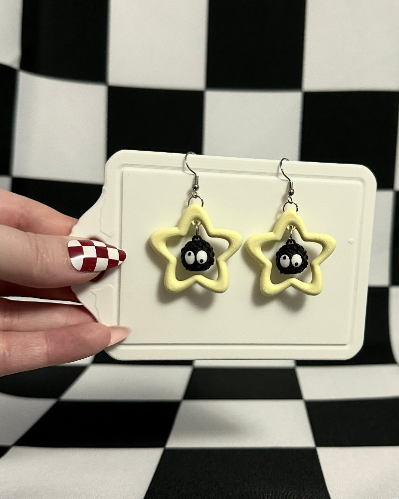 Star-shaped earrings on a display card held against a checkered background