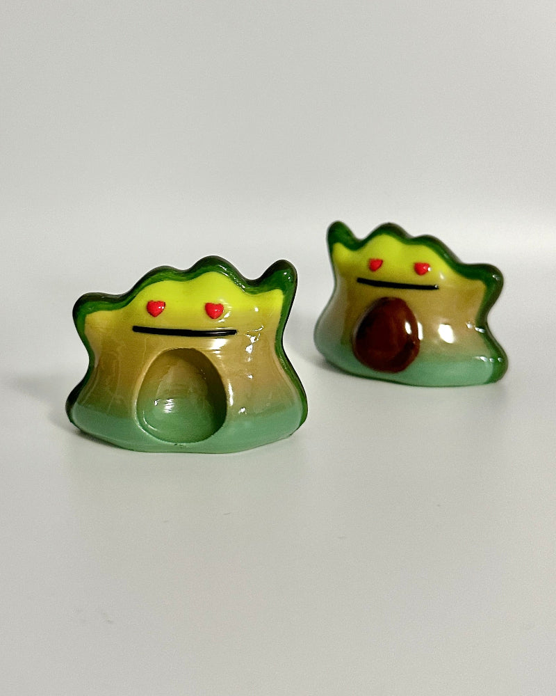 Two avocado shaped ceramic items on a white background