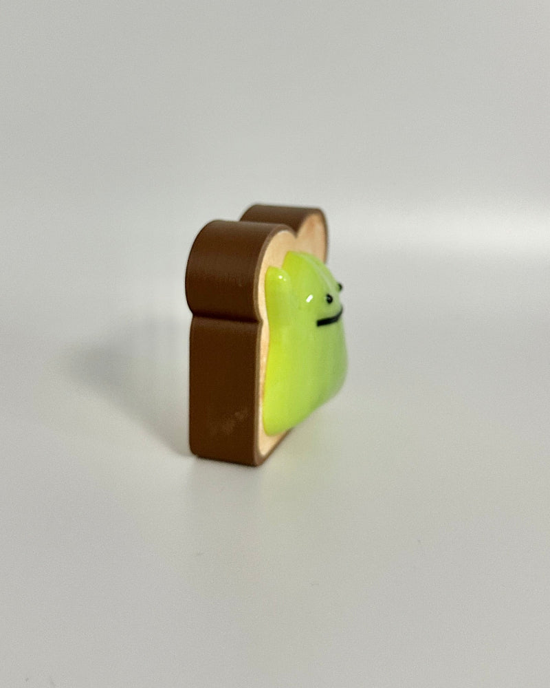 Small green and brown toy figure on a white background