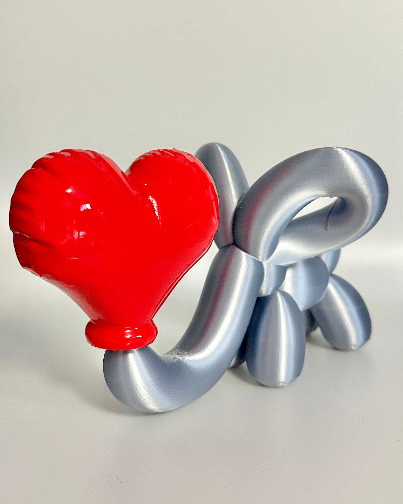 Decorative item with a red heart and silver 'LOVE' letters on a white background