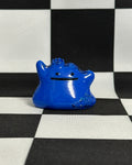 Blue monster-shaped object on a black and white checkered background