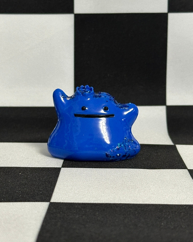 Blue monster-shaped object on a black and white checkered background