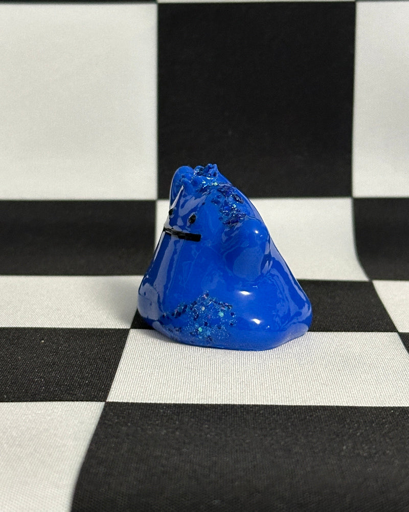 Blue glass object on a black and white checkered background