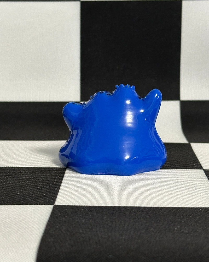 Blue plastic object on a black and white checkered background