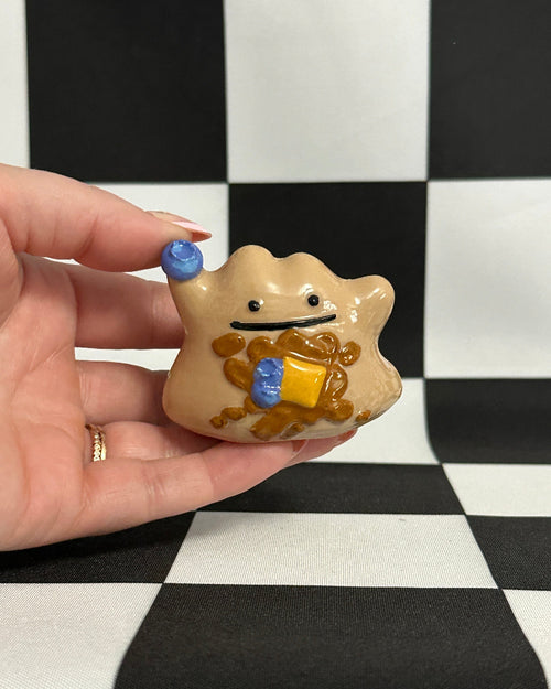 Hand holding a small star-shaped figurine with a checkered background
