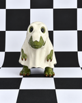 A small ghost-shaped figurine or toy with a white body and green face, hands, and feet, standing on a black-and-white checkered studio background.