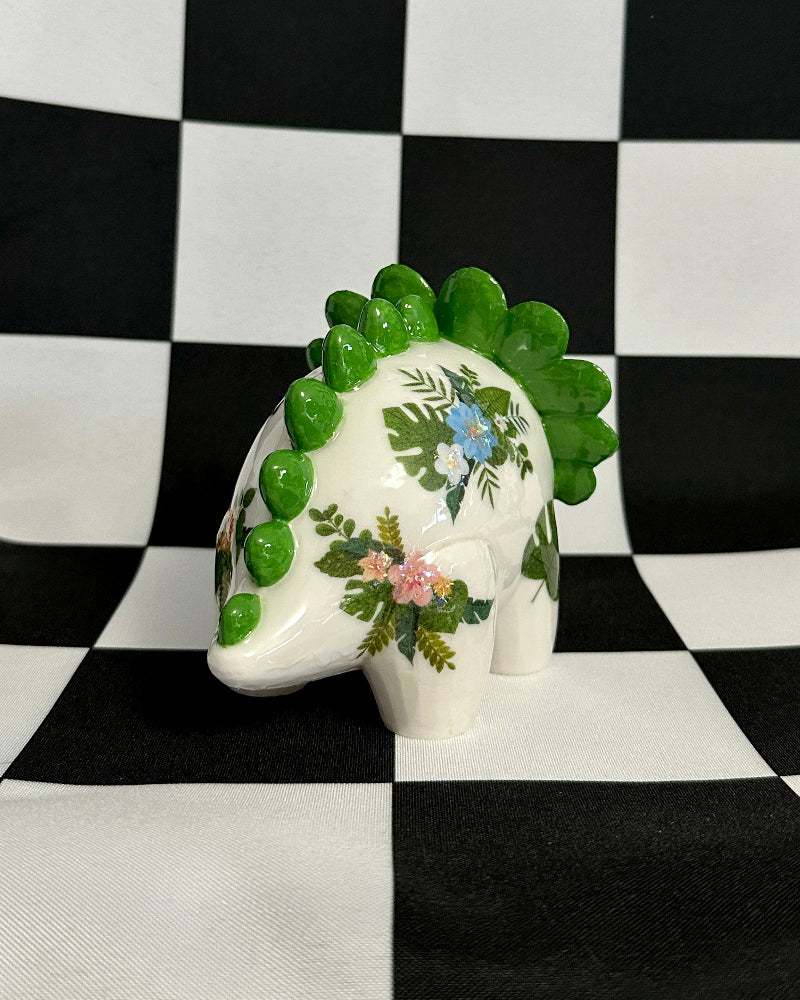 Decorative ceramic elephant with floral patterns on a black and white checkered background