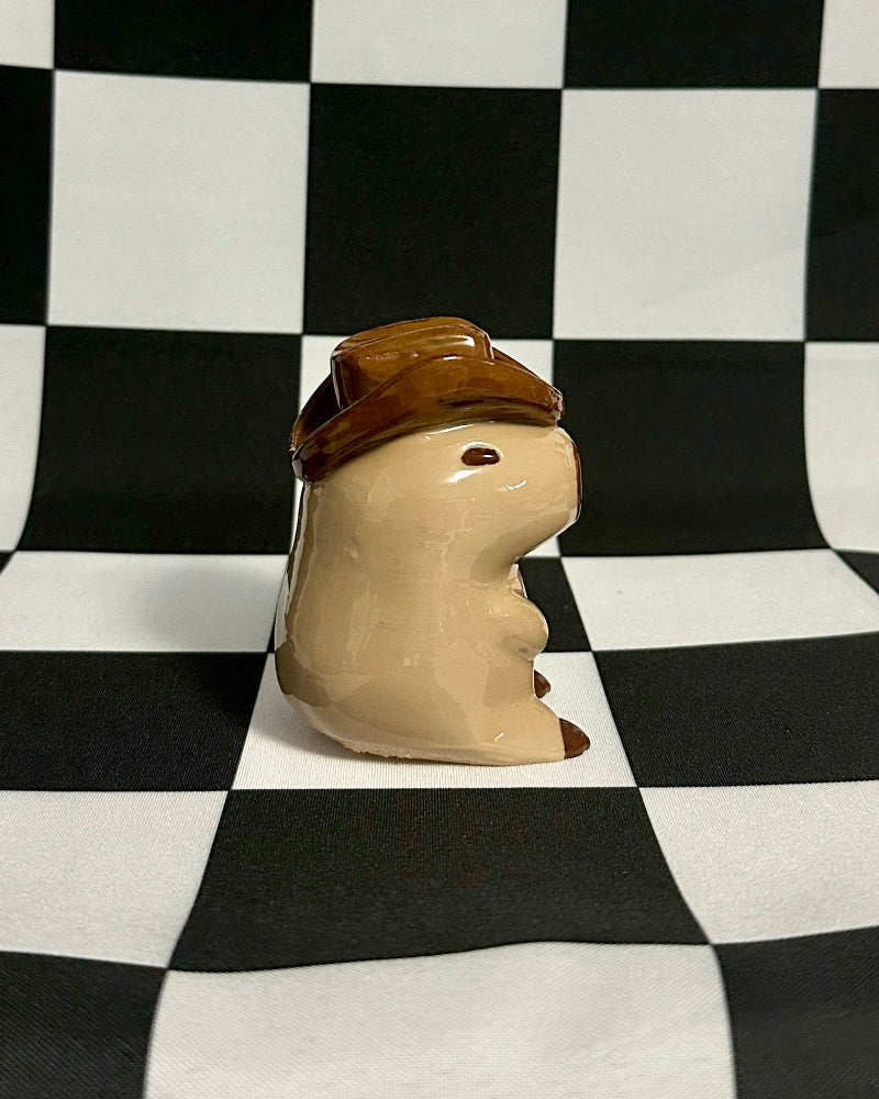 Small figurine with a hat on a black and white checkered background