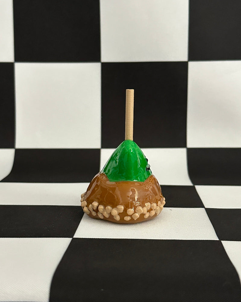 Caramel apple with a green top on a checkered background