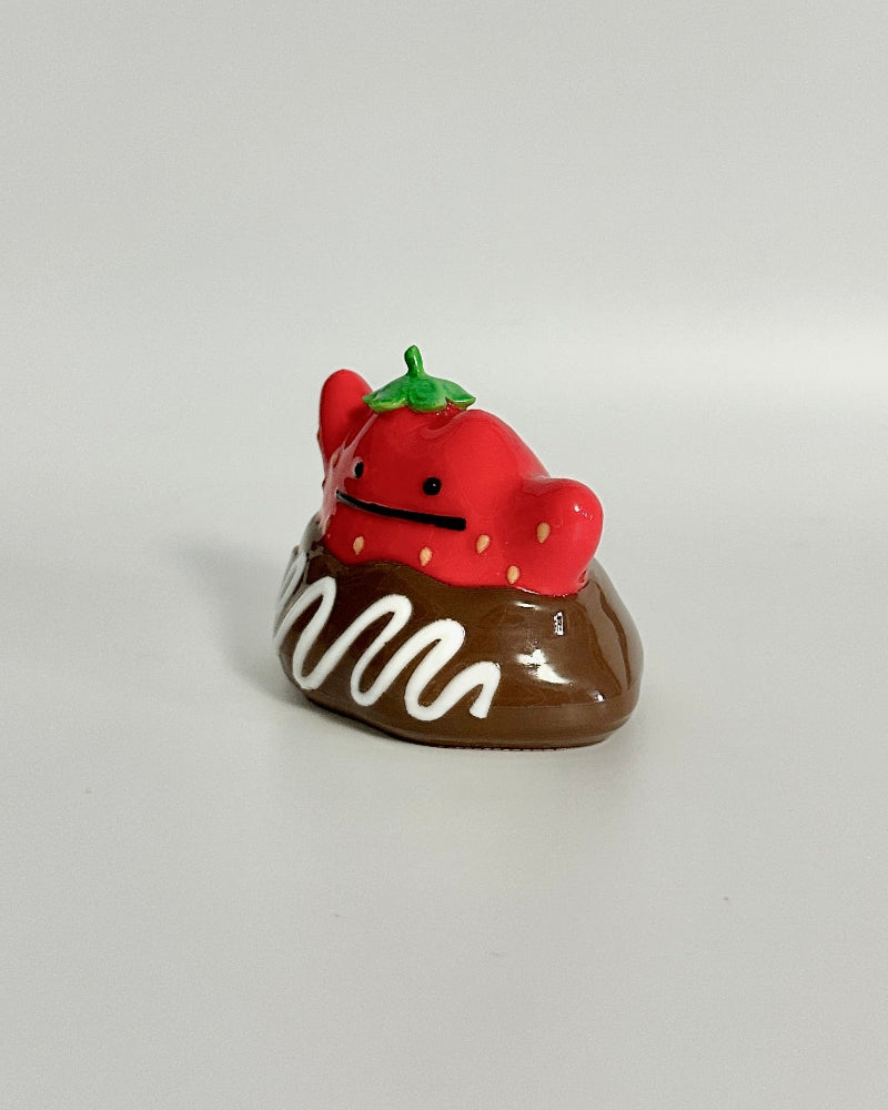 Small chocolate donut figurine with a strawberry on a white background