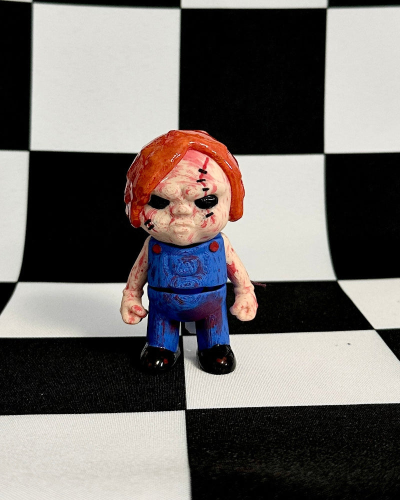 Toy figure with red hair and blue overalls standing on a black and white checkered background