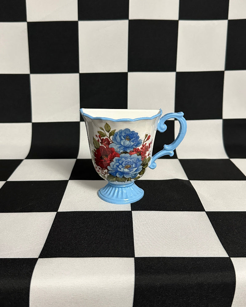 Decorative cup with floral design on a black and white checkered background