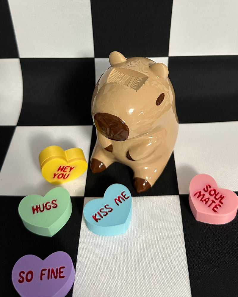 capybara figurine with candy hearts on a checkered background