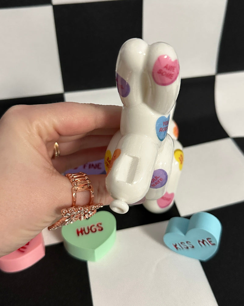 Colorful dog toy with 'HUGS' and 'Kiss Me' text on a checkered background