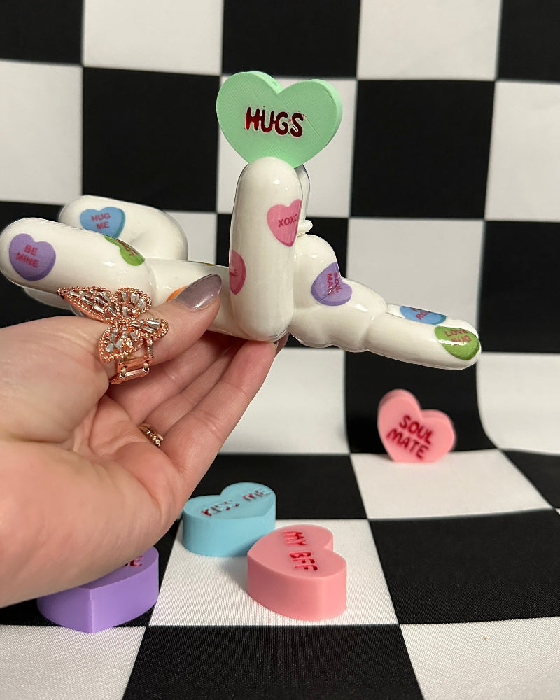 Decorative dog shaped like hearts with 'Hugs' and 'Love' text on a checkered background.