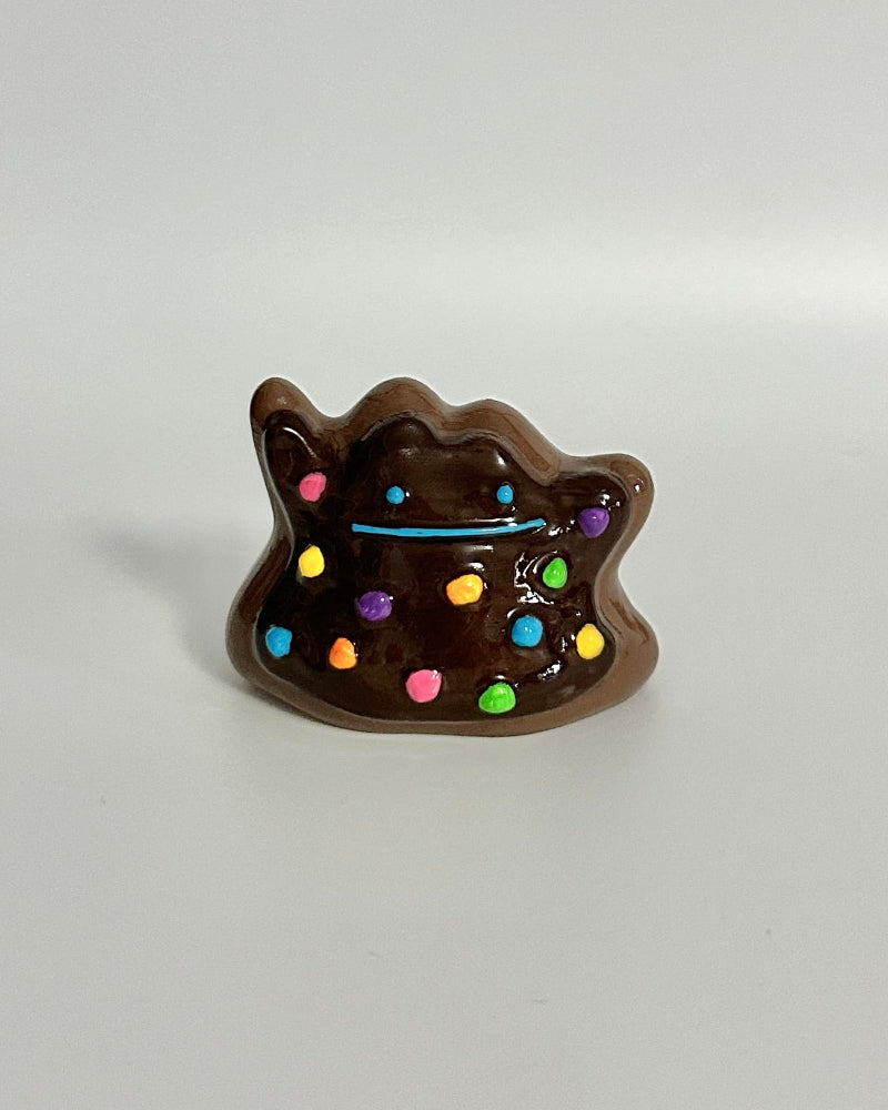 Chocolate cat-shaped container with colorful sprinkles on a white background