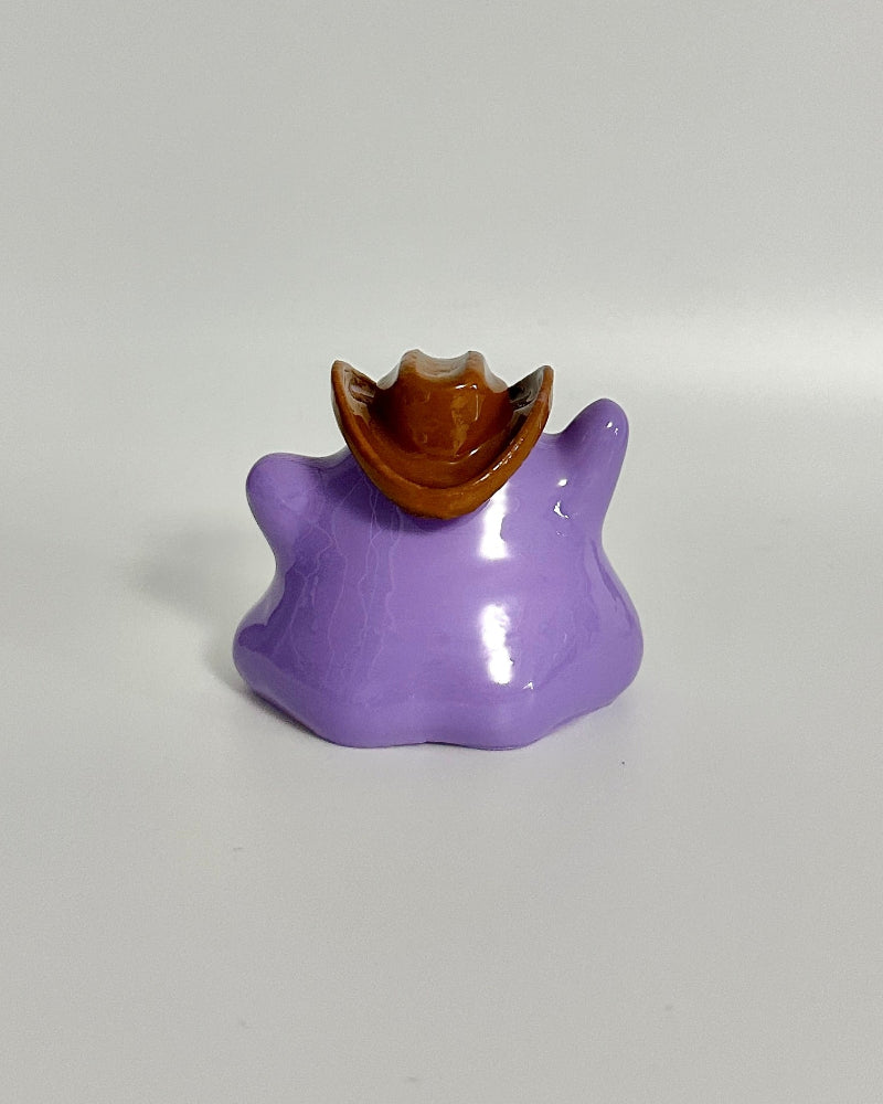 Purple cat-shaped object with a brown top on a white background
