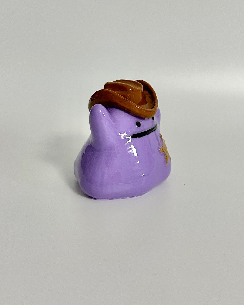 Small purple figurine with a brown top on a white background