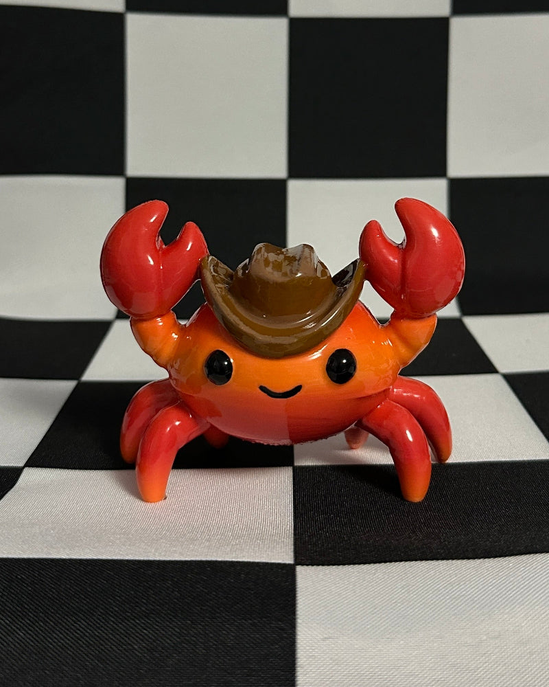 Toy crab figure with a brown shell on a black and white checkered background