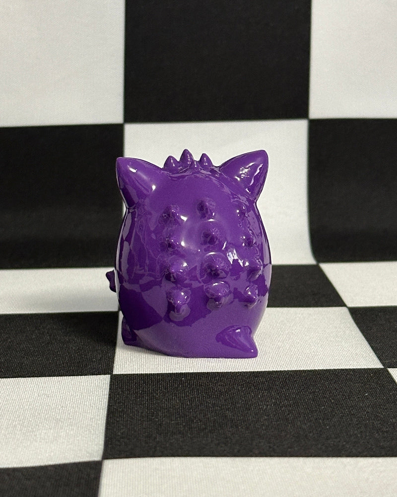 Purple pig-shaped object on a black and white checkered background