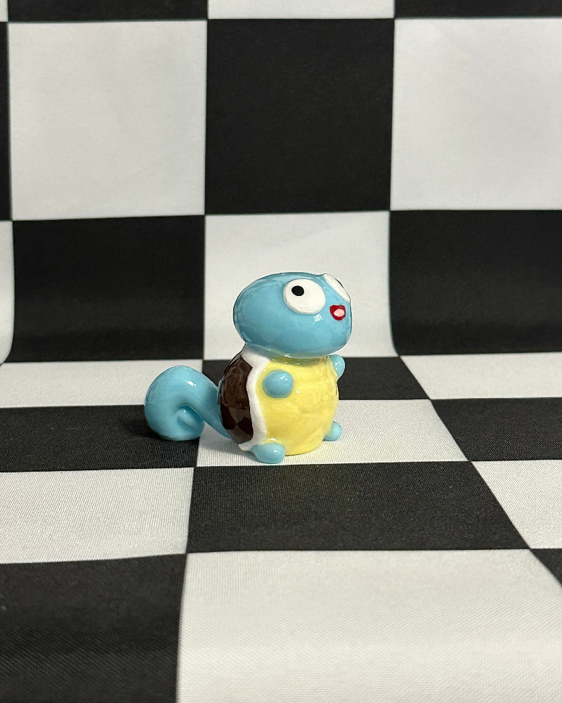 Toy turtle figurine on a black and white checkered background