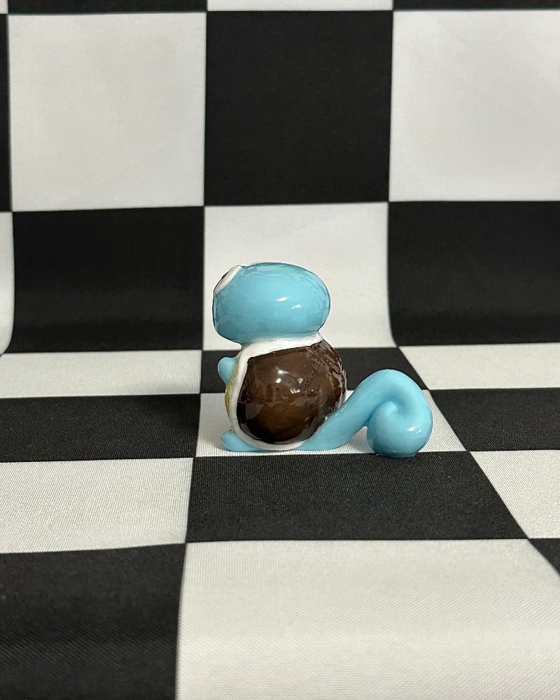 Small figurine sitting on a checkered black and white surface