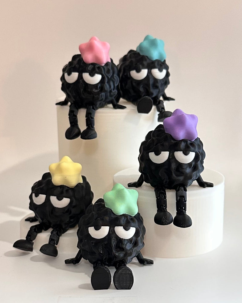 Small black figures with colorful hair on a white surface