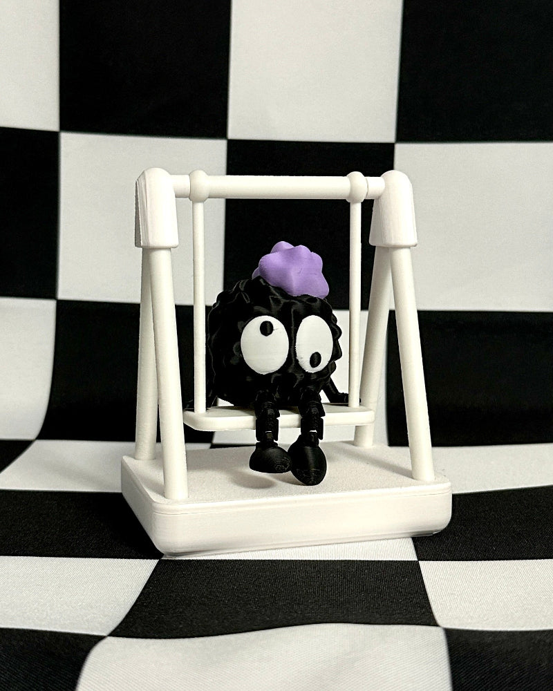 Small figure with a purple hat on a white stand against a black and white checkered background