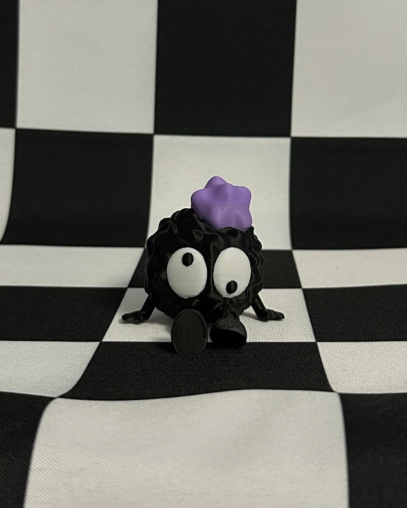 Small black creature with a purple object on its head against a black and white checkered background