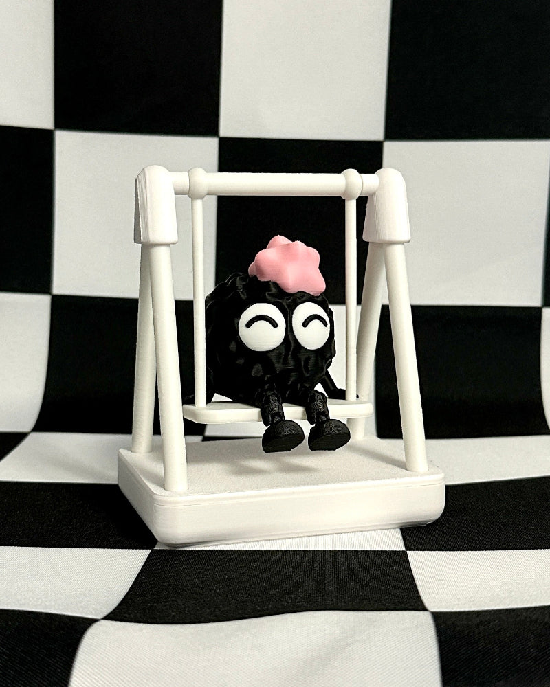Small black and white character with a pink bow on a white swing against a black and white checkered background