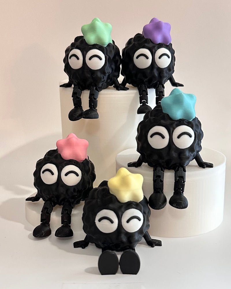 Black cake toppers with colorful hats on a white cake