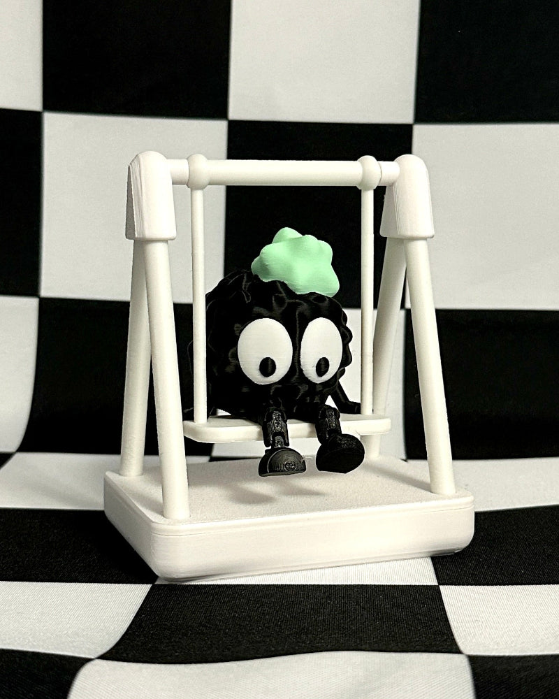 Small black and white figure with a green head on a swing against a black and white checkered background