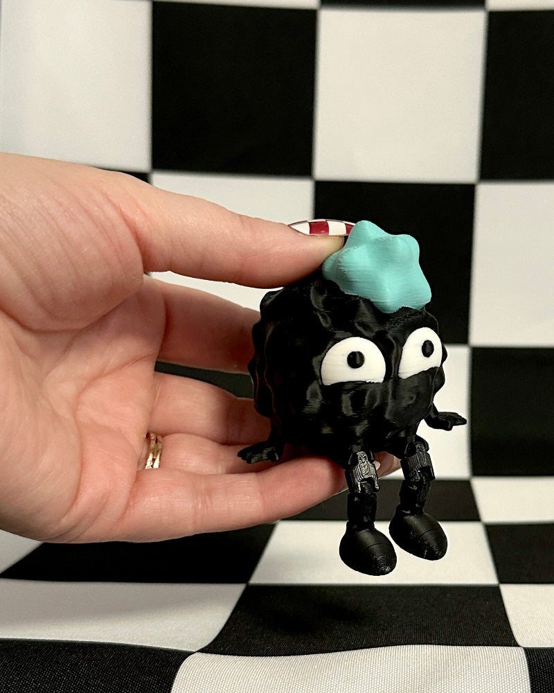 Black figurine with a blue object on a checkered background