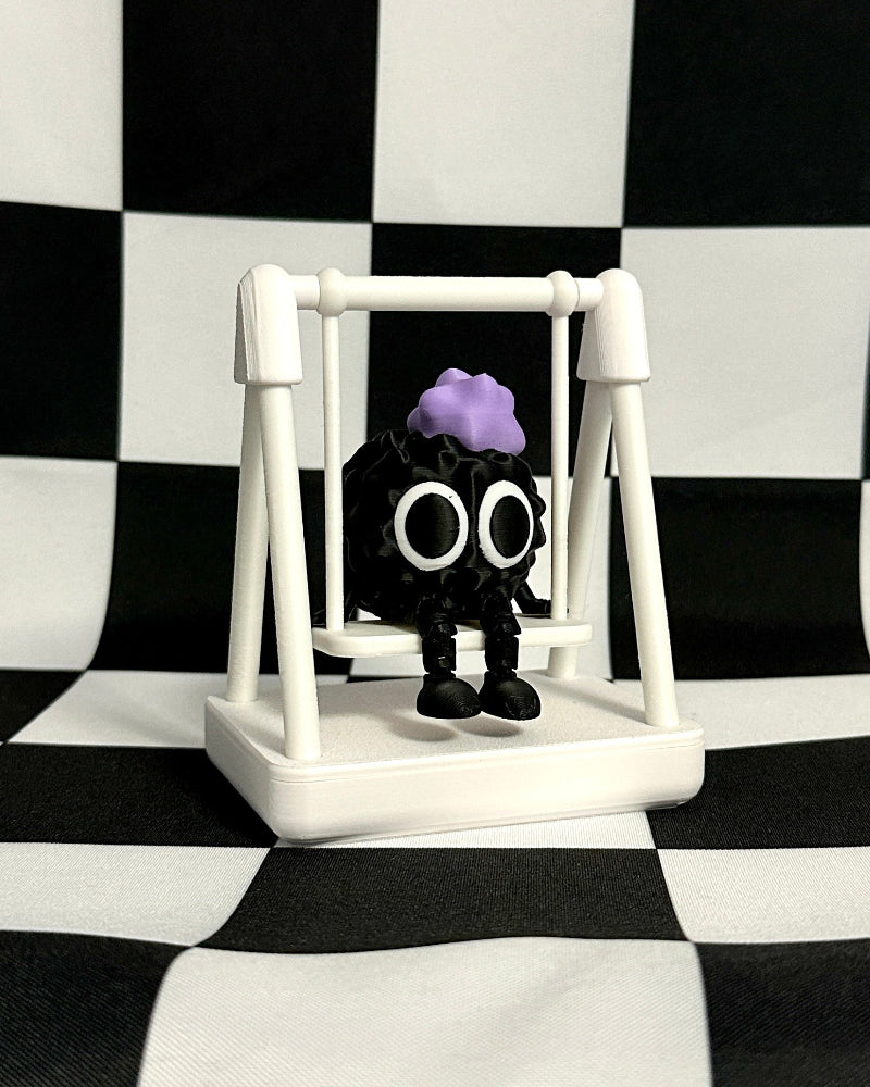 Small figurine on a white stand against a black and white checkered background