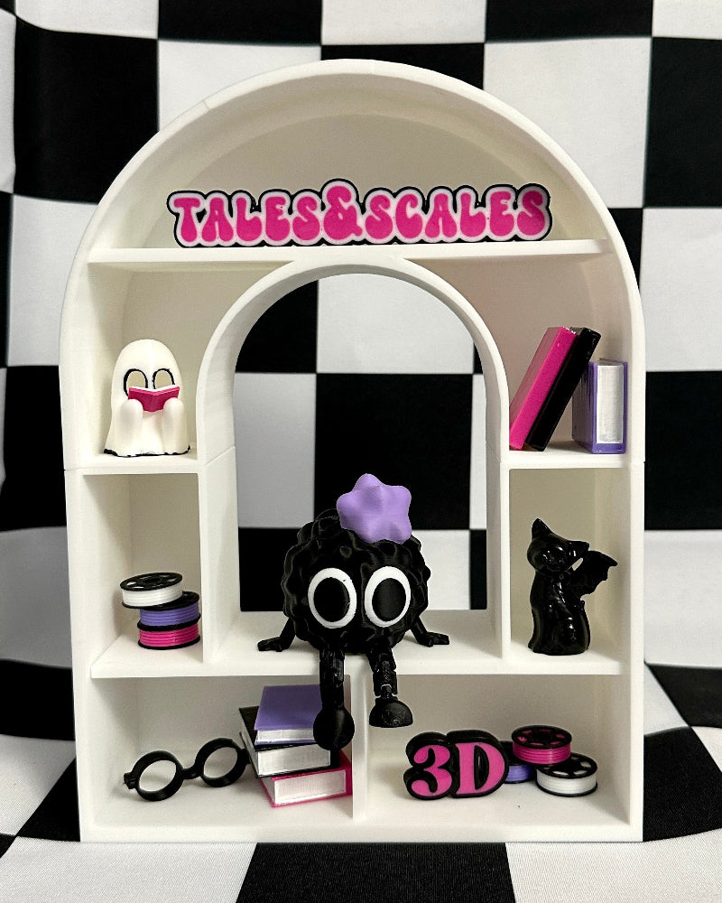 White shelf with toys and 'Tales & Scales' branding on a black and white checkered background