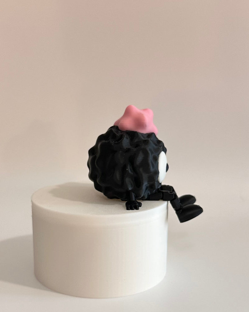 Small black and pink character on a white platform with a neutral background