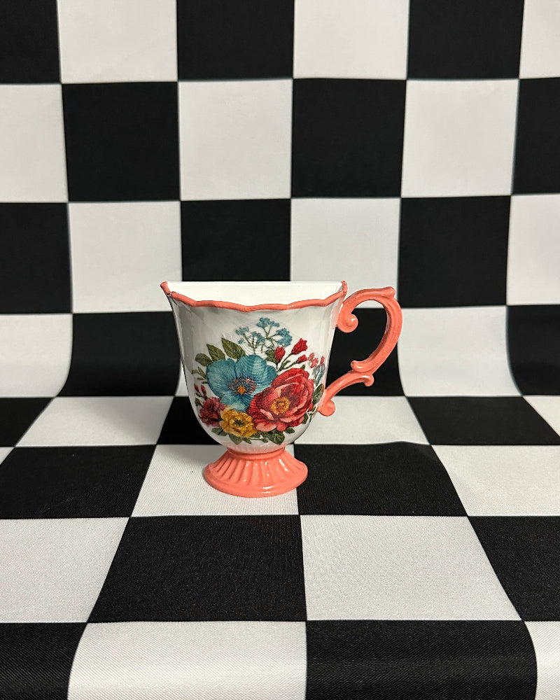 Decorative cup with floral design on a black and white checkered background