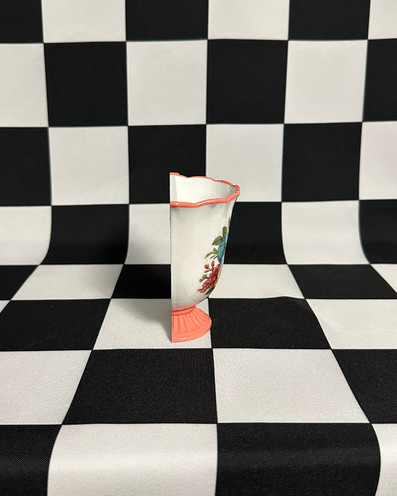 Vase with floral design on a black and white checkered background