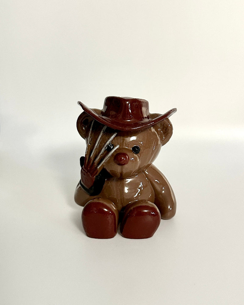 Teddy bear with a cowboy hat and gun on a white background