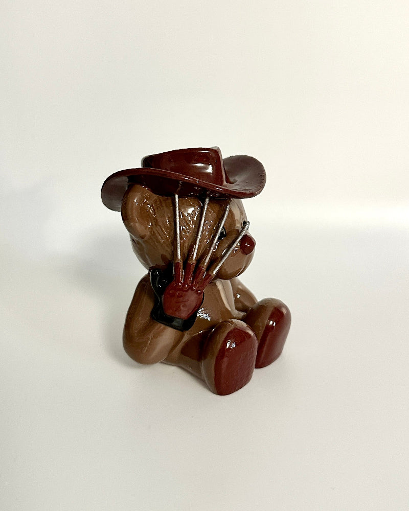 Small brown teddy bear figurine on a white background