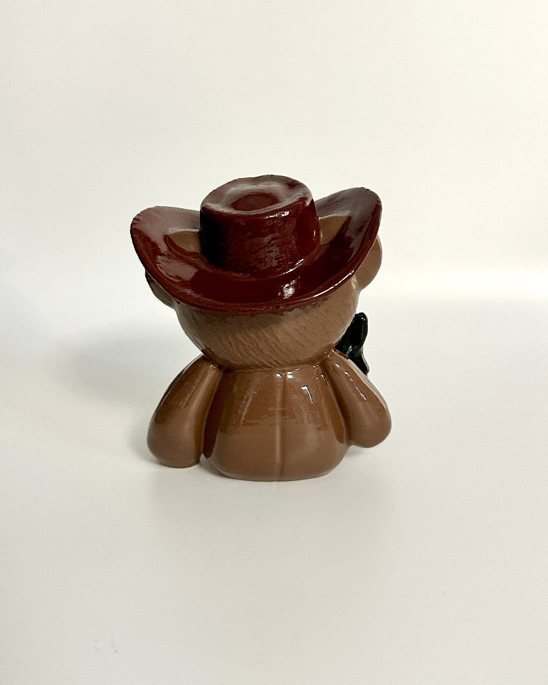 Small figurine with a brown hat on a white background