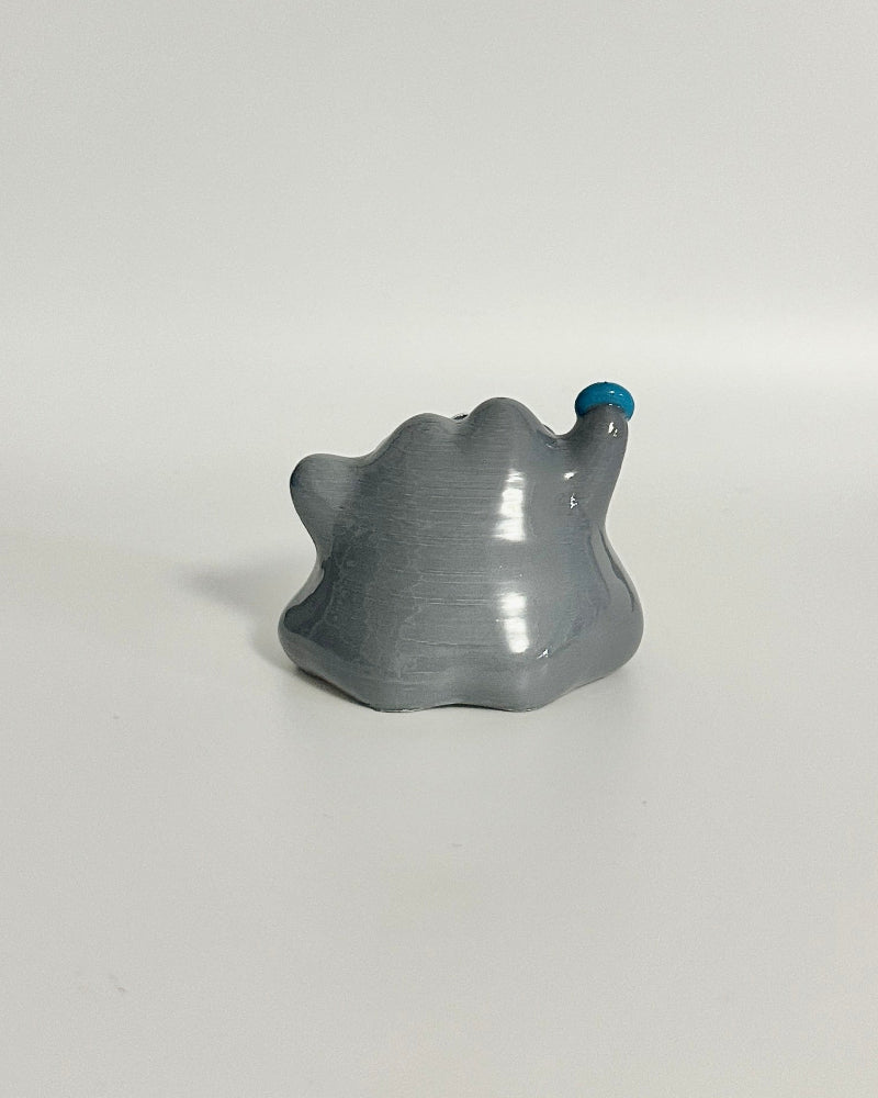 Gray elephant figurine on a white surface with a blurred background