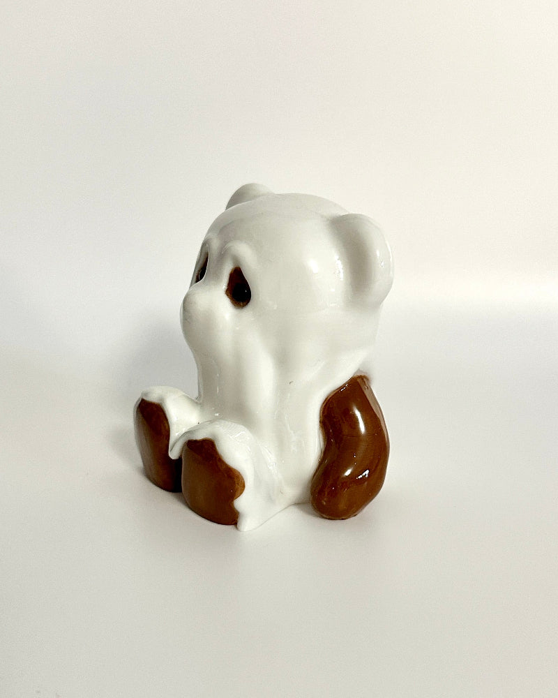 Small ceramic dog figurine on a white surface
