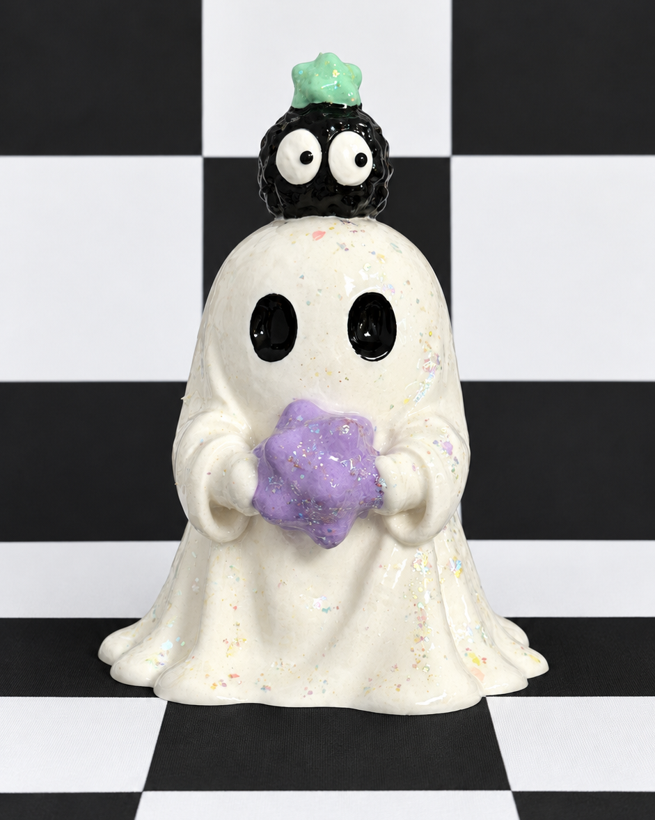 A ceramic ghost figurine holding a purple glittery flower, with a small black creature on its head wearing a green hat, set against a black and white checkered background.