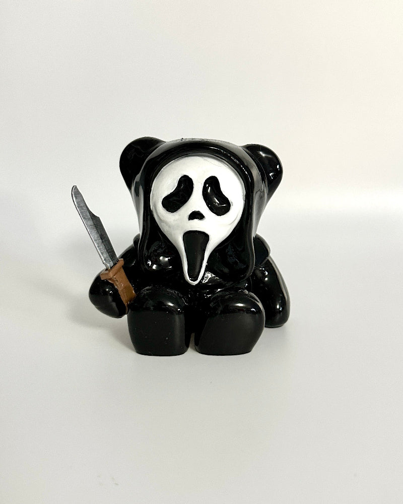 Panda figurine with a mask and knife on a white background