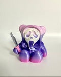 Purple teddy bear with a ghost face and knife on a white background